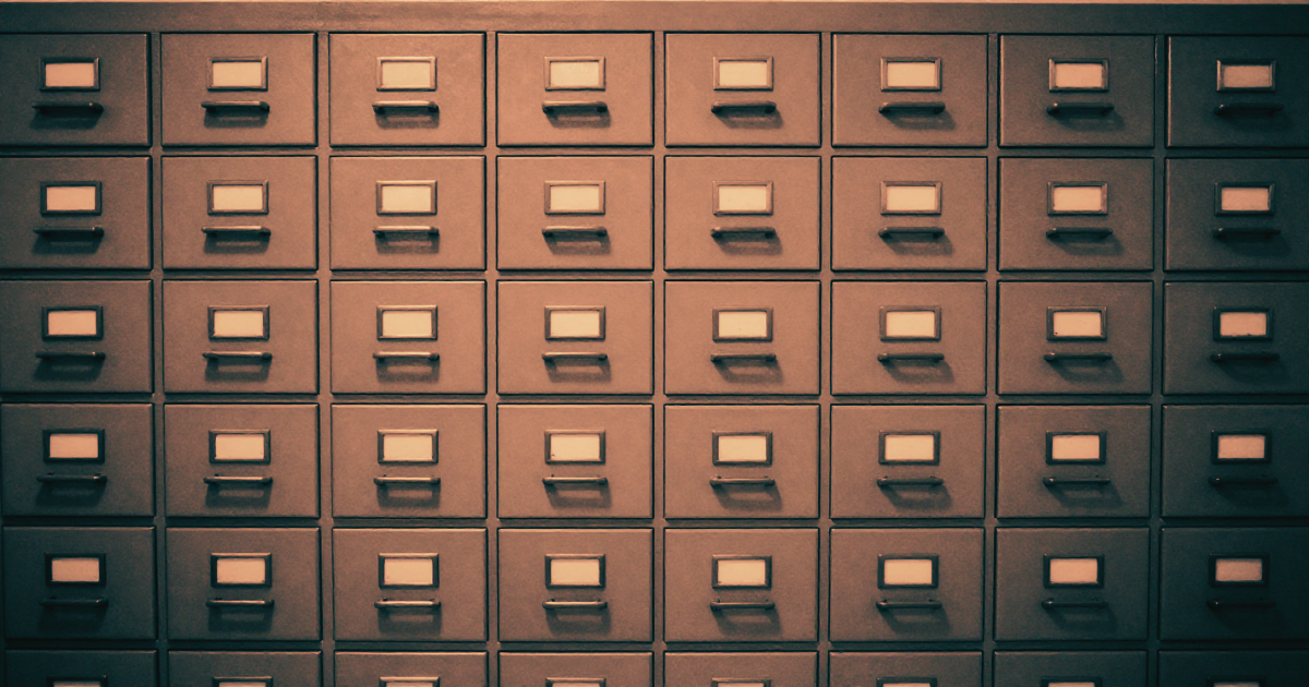 A grid of identical filing cabinets filling the entire frame - indistinguishable, filed and forgotten