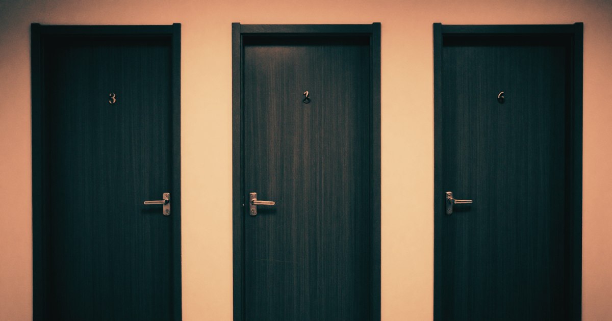 Three identical office doors in a row, each numbered, shot from straight ahead, minimal corridor